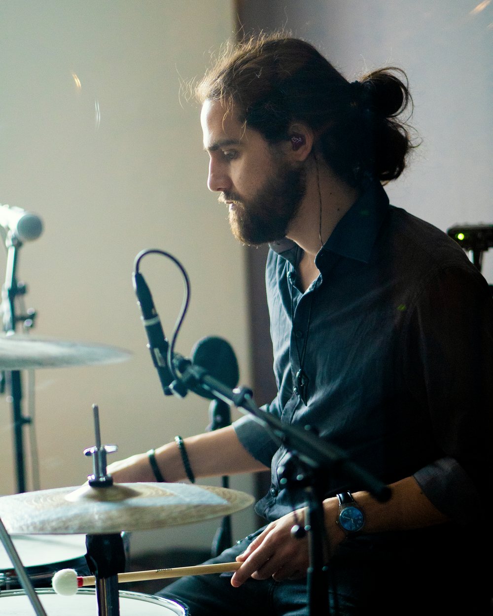 Pier playing, mid-take, with mics around the kit.